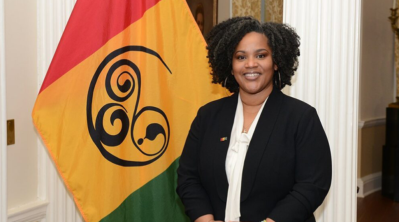 Wendie L. Wilson poses next to the flag she designed to represent Black/African Nova Scotians.